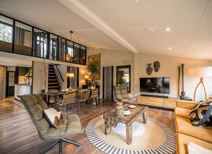 Stilvolles Wohnzimmer des Ferienhauses in Rheezerveen, Vechtstreek, Overijssel mit moderner Einrichtung und Zugang zum Wintergarten.