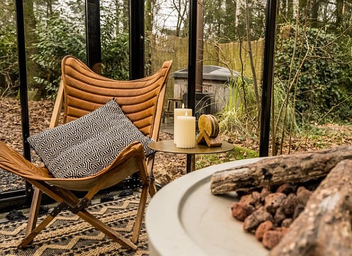 Geraeumiger Wohnraum im Ferienhaus in Rheezerveen, Vechtstreek, Overijssel mit Holzboeden und einer gemuetlichen Sitzecke.