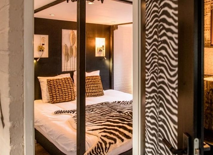 Geraeumiger Wohnraum im Ferienhaus in Rheezerveen, Vechtstreek, Overijssel mit Holzboeden und einer gemuetlichen Sitzecke.