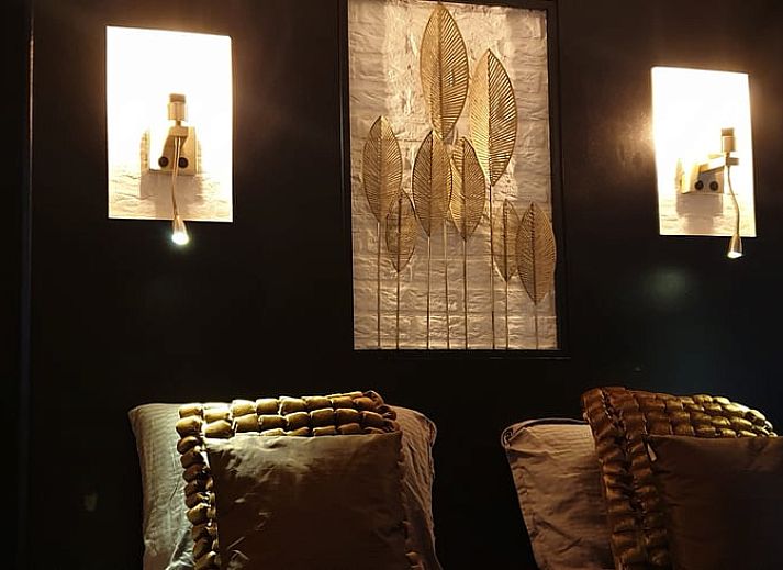 Geraeumiger Wohnraum im Ferienhaus in Rheezerveen, Vechtstreek, Overijssel mit Holzboeden und einer gemuetlichen Sitzecke.