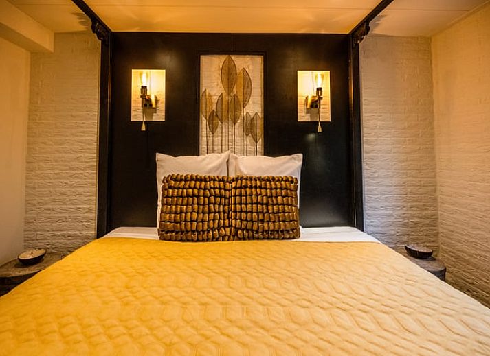 Geraeumiger Wohnraum im Ferienhaus in Rheezerveen, Vechtstreek, Overijssel mit Holzboeden und einer gemuetlichen Sitzecke.