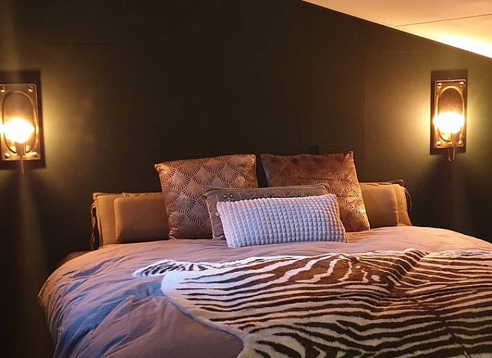 Esstisch im Ferienhaus in Rheezerveen, Vechtstreek, Overijssel mit dekorativen Accessoires und warmer Beleuchtung.