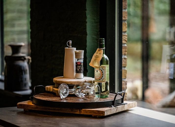 Esstisch im Ferienhaus in Rheezerveen, Vechtstreek, Overijssel mit dekorativen Accessoires und warmer Beleuchtung.