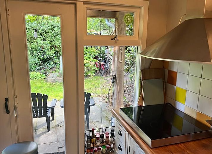 Gemuetliches Wohnzimmer des Ferienhauses in Arrien mit Blick auf den Garten in Vechtstreek, Overijssel.