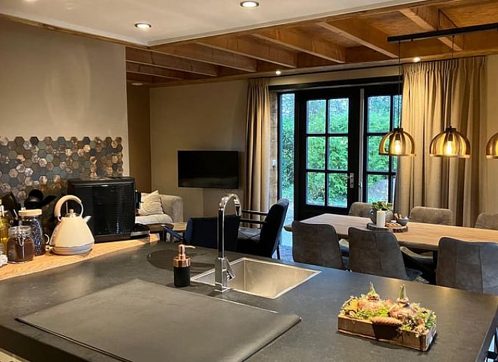 Cozy indoor area of Holiday Home in Giethmen, Overijssel, with atmospheric lighting and modern kitchen.