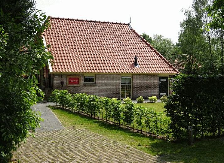 Gezellige woonkamer van vakantiehuis AA-Reestryck in IJhorst, Overijssel, met comfortabele stoelen en eetruimte.