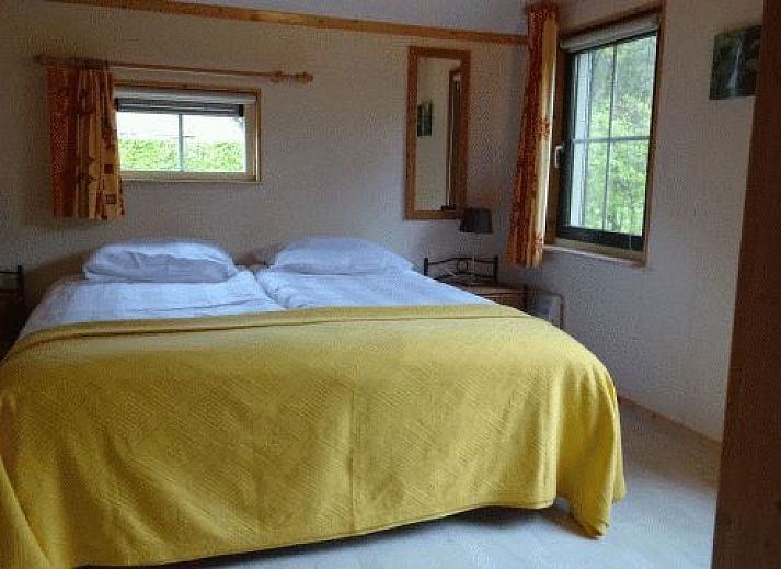 Gezellige woonkamer van vakantiehuis AA-Reestryck in IJhorst, Overijssel, met comfortabele stoelen en eetruimte.