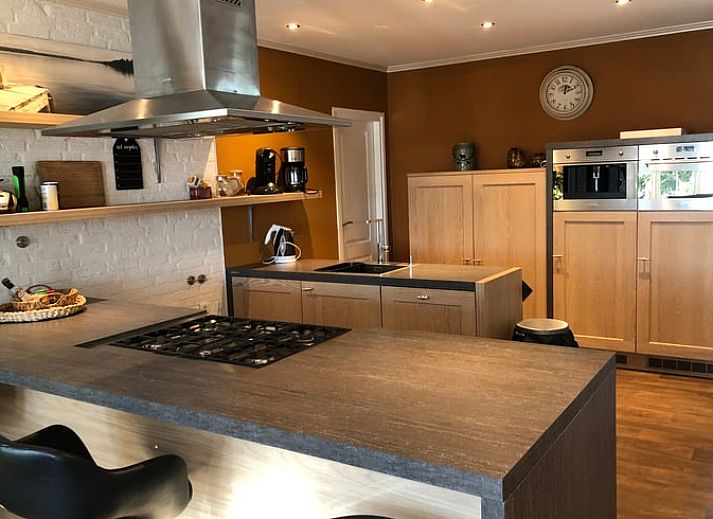 Rode gevel van Vakantiehuis in Bergentheim, omgeven door bloeiende tuinen in de Vechtstreek, Overijssel.