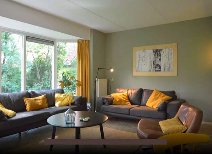 Gezellige woonkamer in Huisje in Lemele, Vechtstreek, Overijssel met comfortabele banken en uitzicht op de tuin.