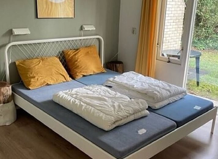 Lichte woonkamer van vakantiehuis Huisje in Lemele, Overijssel met grote ramen en groene omgeving.