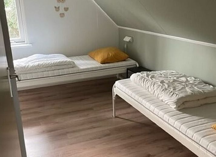 Lichte woonkamer van vakantiehuis Huisje in Lemele, Overijssel met grote ramen en groene omgeving.