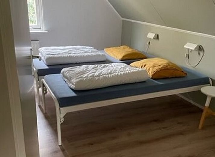 Lichte woonkamer van vakantiehuis Huisje in Lemele, Overijssel met grote ramen en groene omgeving.