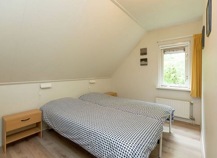 Lichte woonkamer van vakantiehuis Huisje in Lemele, Overijssel met grote ramen en groene omgeving.