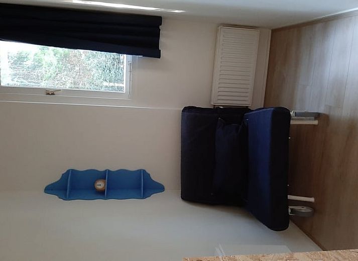 Gemuetliches Wohnzimmer des Ferienhauses in Stegeren, umgeben von Natur in der Region Vecht, Overijssel, mit grossem Fenster und bequemer Sitzecke.