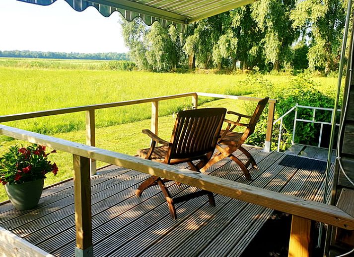 Uitzicht vanaf het terras van Huisje in Dedemsvaart op weelderige velden in Overijssel.