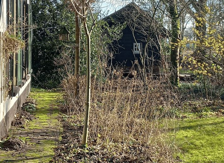 Sfeervol verlicht vakantiehuis in Brucht, Vechtstreek, Overijssel in de avondschemering.