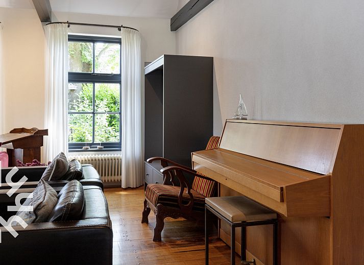 Rustieke tuin van OV553 vakantiehuis in Giethoorn met zitje en groene omgeving voor ontspanning.