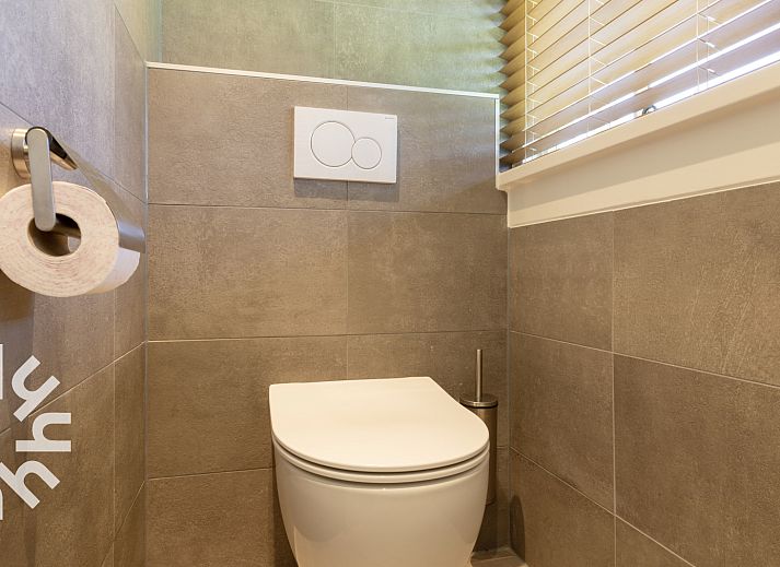 Rustieke tuin van OV553 vakantiehuis in Giethoorn met zitje en groene omgeving voor ontspanning.