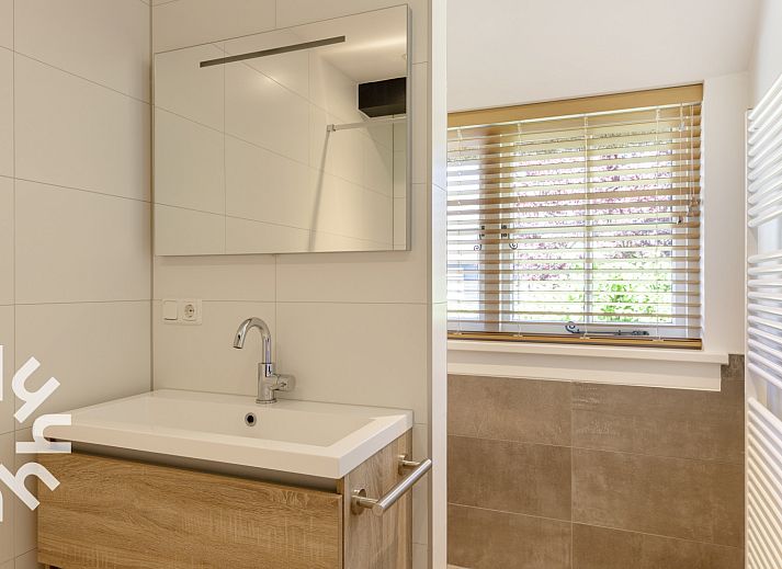 Charmante gevel van OV553 vakantiehuis in Giethoorn, Noordwest Overijssel, met rieten dak en groene heg.