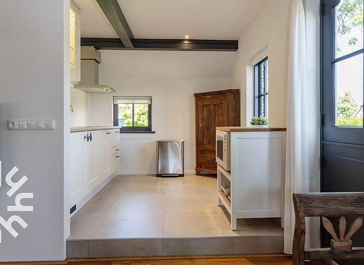 Gezellige keuken van OV553 vakantiehuis in Giethoorn met moderne apparatuur en houten elementen.
