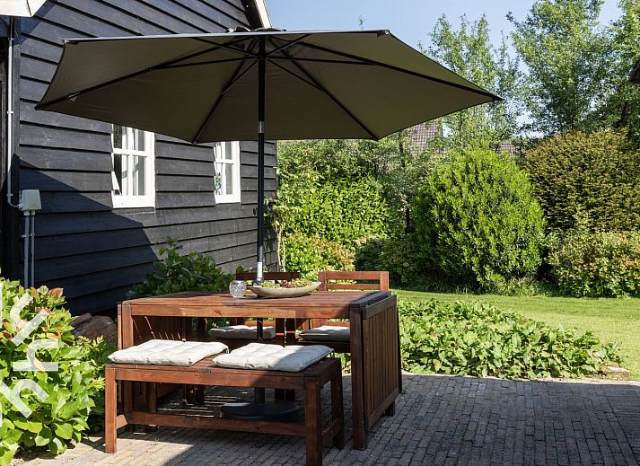 Sfeervolle slaapkamer in OV592 vakantiehuis Giethoorn, met houten bed en raam met uitzicht.