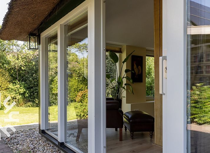 Sfeervolle slaapkamer in OV592 vakantiehuis Giethoorn, met houten bed en raam met uitzicht.