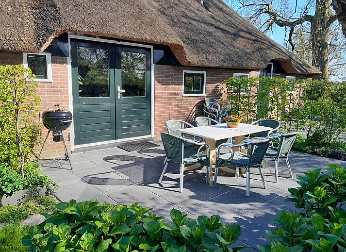 Aussenbereich des Ferienhauses OV603 in Giethoorn, Overijssel mit Terrasse und Gartentisch.