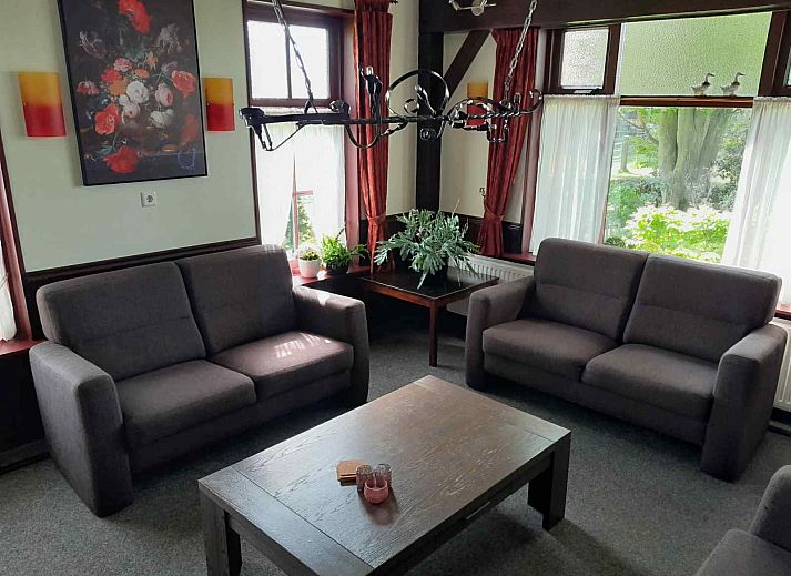 Attractive garden of vacation home OV601 in Giethoorn, Overijssel, with colorful flowers and paved path.