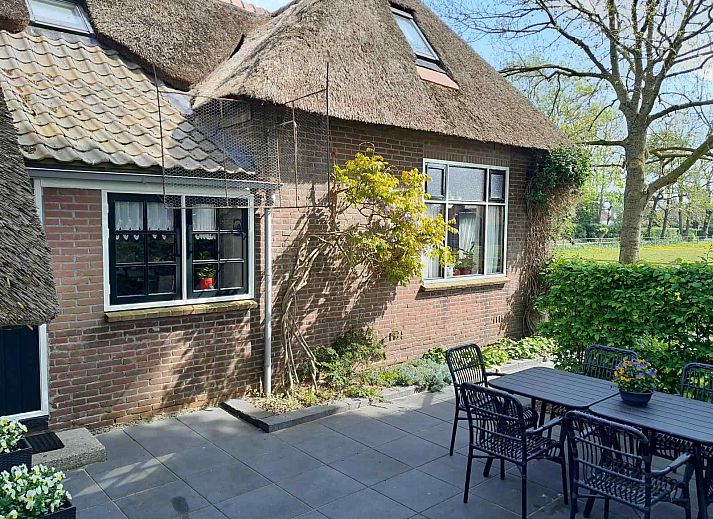 Entrance to vacation home OV601 in Giethoorn, surrounded by lush green hedges and trees.