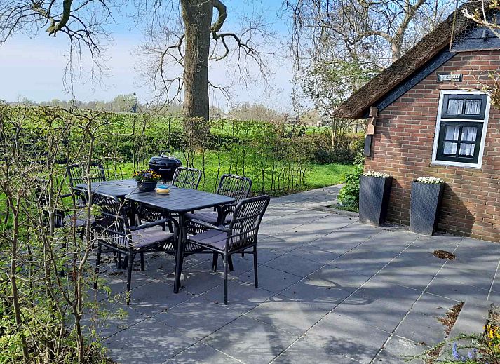 Entrance to vacation home OV601 in Giethoorn, surrounded by lush green hedges and trees.