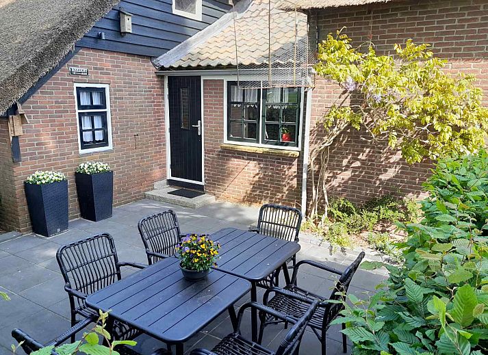 Entrance to vacation home OV601 in Giethoorn, surrounded by lush green hedges and trees.