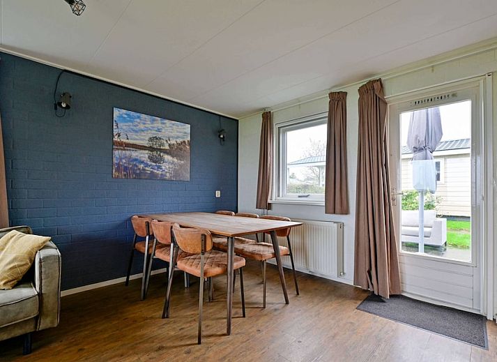 De Wijde Blik 6, ein komfortabler Bungalow in Giethoorn, Overijssel, mit einer schoenen Terrasse am Wasser und einer gruenen Umgebung.