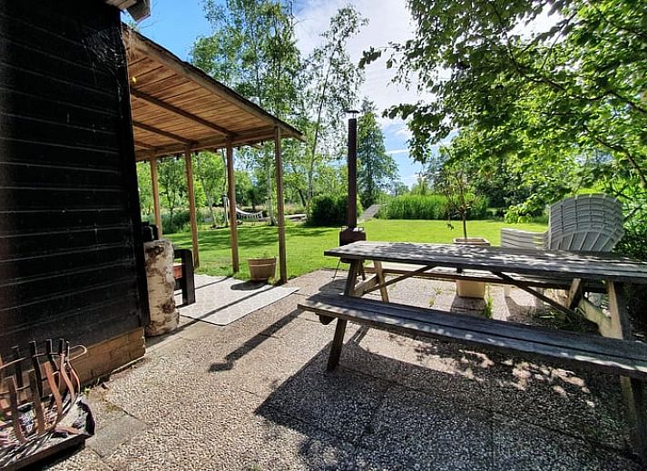Ruhiges Wasser im Ferienhaus in Giethoorn, einem schoenen Ferienhaus in Overijssel, mit einer Holzbruecke und bunten Kissen.