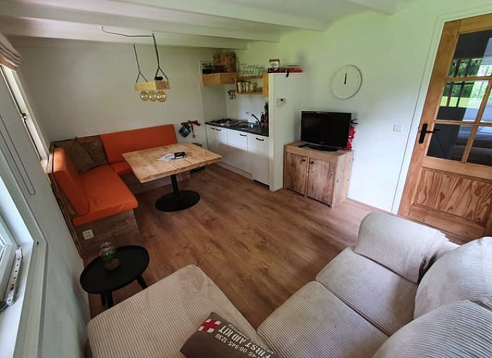 Ruhiges Wasser im Ferienhaus in Giethoorn, einem schoenen Ferienhaus in Overijssel, mit einer Holzbruecke und bunten Kissen.