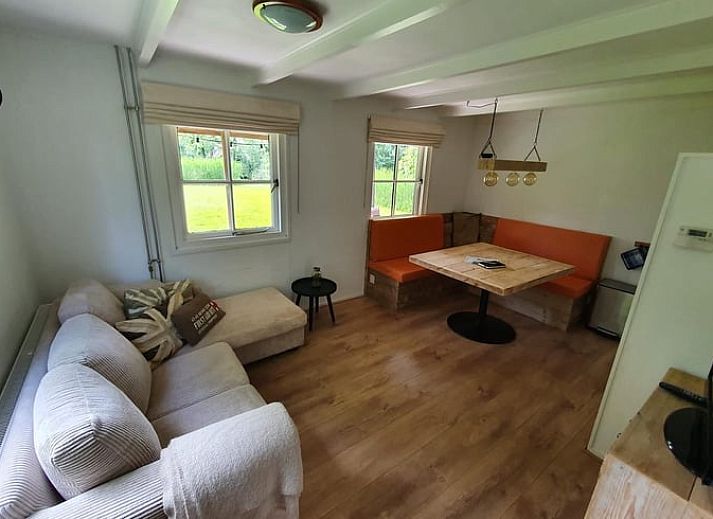 Ruhiges Wasser im Ferienhaus in Giethoorn, einem schoenen Ferienhaus in Overijssel, mit einer Holzbruecke und bunten Kissen.