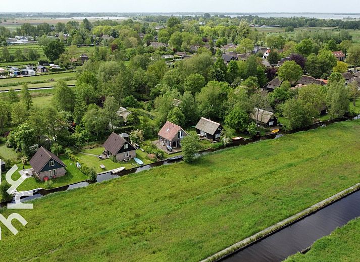 Slaapkamer in vakantiehuis OV207, Giethoorn, met rustiek houten interieur en uitzicht op de natuur.