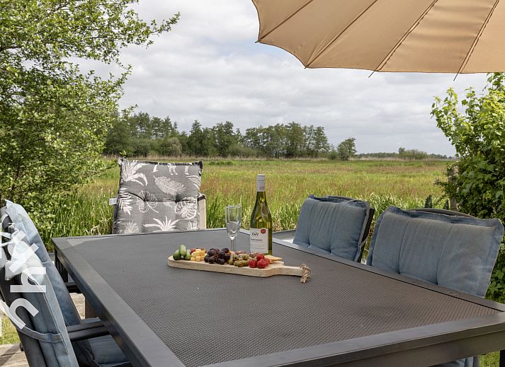 Slaapkamer in vakantiehuis OV207, Giethoorn, met rustiek houten interieur en uitzicht op de natuur.