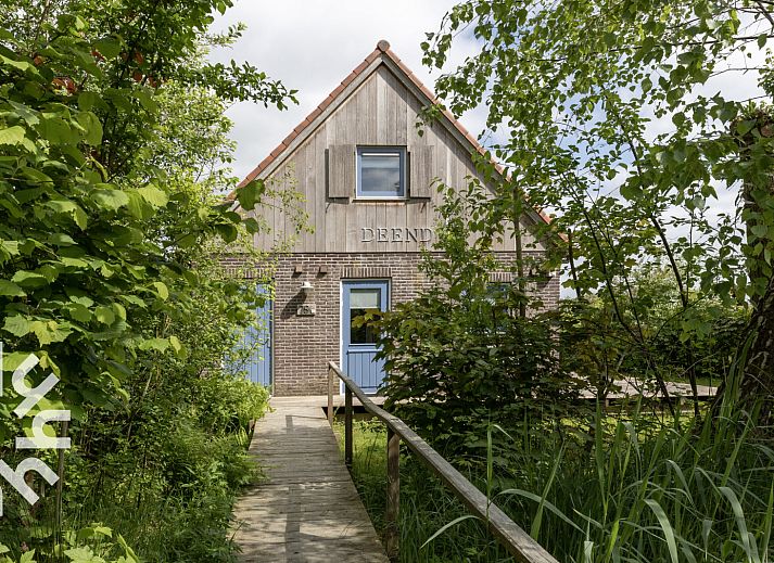 Slaapkamer in vakantiehuis OV207, Giethoorn, met rustiek houten interieur en uitzicht op de natuur.