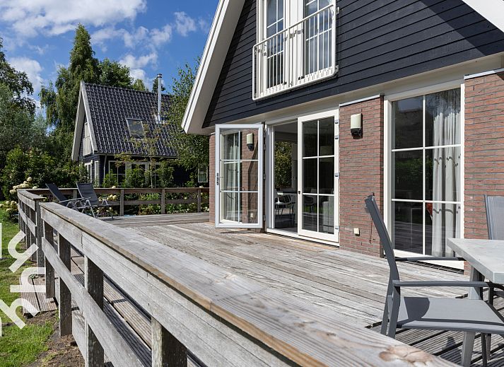 Charming facade of vacation home OV688 in Giethoorn, Overijssel, with classic windows and natural surroundings.