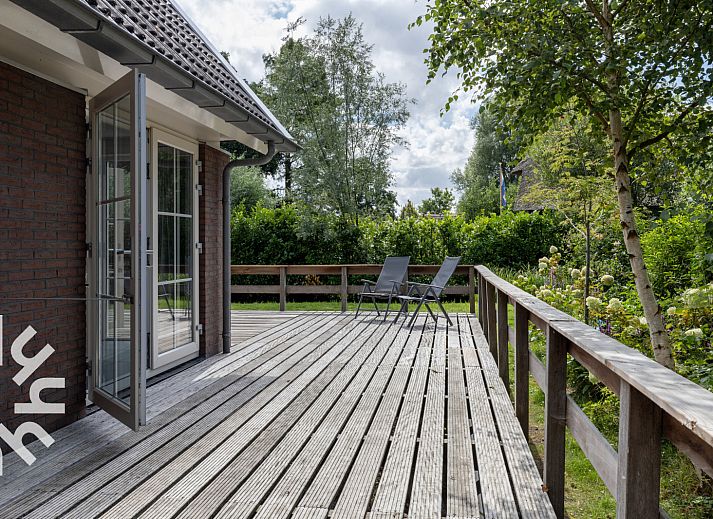 Charming facade of vacation home OV688 in Giethoorn, Overijssel, with classic windows and natural surroundings.