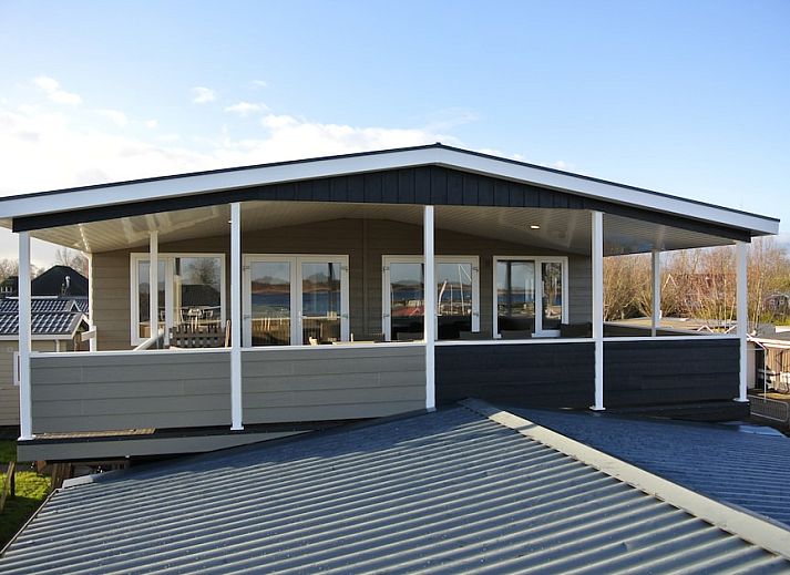 Gezellige woonkamer in vakantiehuis Kraaiennest 12, Giethoorn, met comfortabele zithoek en uitzicht op de omgeving van Noordwest Overijssel.