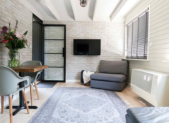 Stylish living room in vacation home OV206, Giethoorn, with modern furnishings and lots of light.