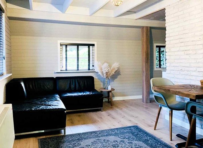 Stylish living room in vacation home OV206, Giethoorn, with modern furnishings and lots of light.
