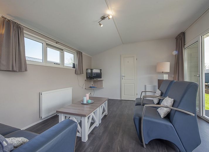 Gemuetliches Wohnzimmer im Chalet Stern 6 in Giethoorn, Nordwest Overijssel, mit viel Licht und Aussicht auf die gruene Umgebung.