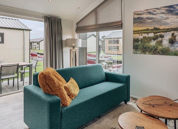 Gezellige woonkamer van Blauwborst 4 chalet in Giethoorn, Noordwest Overijssel, met moderne inrichting en uitzicht op groene omgeving.