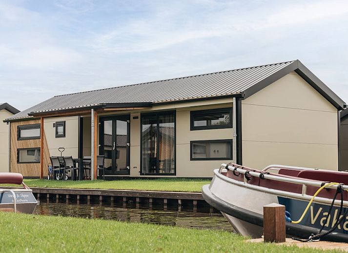 Gezellige woonkamer van chalet Blauwborst 4 in Giethoorn, Overijssel, met uitzicht op het terras en de groene omgeving.