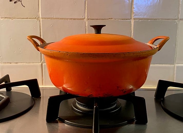 Gemuetliches Wohnzimmer im Ferienhaus in Giethoorn mit Kamin und bequemen Sitzgelegenheiten.