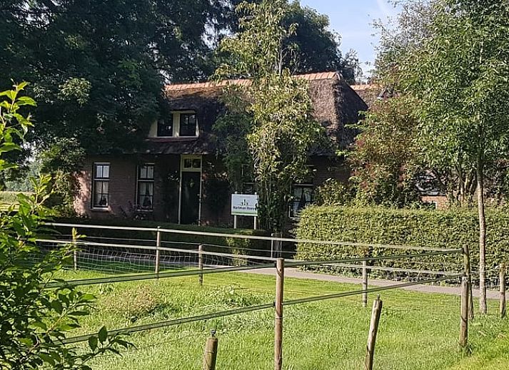 Authentiek bakstenen Vakantiehuisje in Giethoorn omgeven door groen in Noordwest Overijssel, Overijssel.