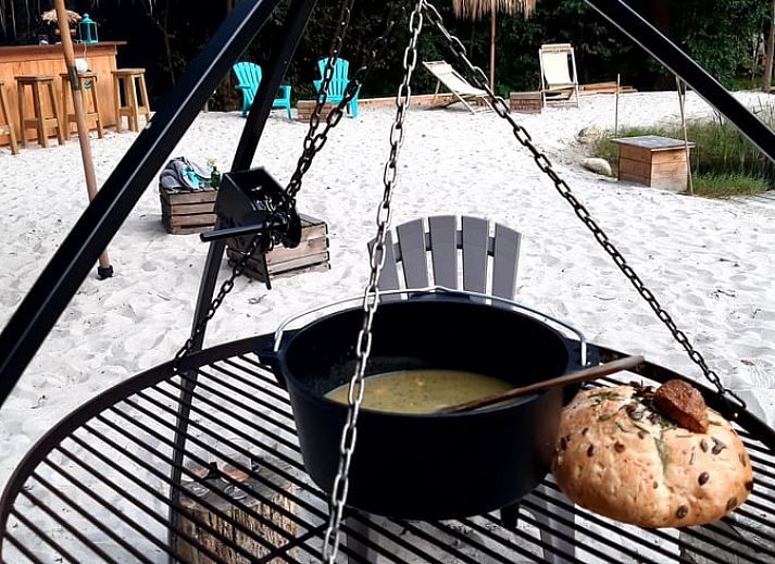 Rustic wooden terrace overlooking the pond at Cottage in De Bult, northwest Overijssel, surrounded by lush nature.