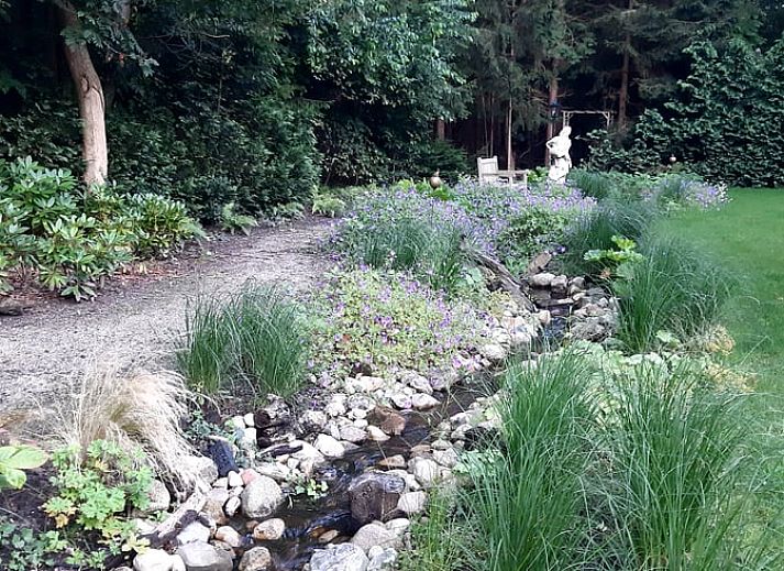 Charming facade of Holiday Home in De Bult, Overijssel, with flowering hydrangeas and an inviting entrance.